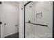 Elegant bathroom shower with glass enclosure, a shelf, and dark hardware at 927 Cathey Rd, Charlotte, NC 28214