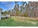 Backyard with lush green lawn, retaining wall, iron fence and deck at 11419 Rising Star Ct, Charlotte, NC 28215