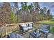 View of outdoor furniture on wooden deck overlooking wooded backyard at 11419 Rising Star Ct, Charlotte, NC 28215