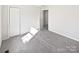 Bedroom with grey carpet, closet, and sunlit window at 153 Pattys Pl, Stony Point, NC 28678