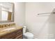 Bathroom with granite countertop, wood vanity, toilet, mirror, and tub/shower at 2008 Surefire Ct, Denver, NC 28037