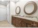 Bathroom featuring double vanity with granite countertops and two decorative framed mirrors at 2008 Surefire Ct, Denver, NC 28037