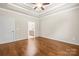 This bedroom has hardwood floors, white trim, ceiling fan, and an open ensuite bathroom at 2008 Surefire Ct, Denver, NC 28037