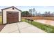 Community grilling area featuring three barbecue grills, a storage shed and a concrete patio by a pond at 2008 Surefire Ct, Denver, NC 28037