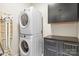 Laundry room with a stacked washer and dryer, cabinets with dark countertops, and an ironing board at 2008 Surefire Ct, Denver, NC 28037
