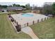 Community pool with a concrete deck, black iron fence with brick columns, and well-maintained lawn at 2008 Surefire Ct, Denver, NC 28037