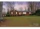 Charming brick home exterior with black shutters and a walkway, pictured at dusk at 2044 Birchcrest Dr, Charlotte, NC 28205