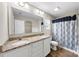 Bright bathroom featuring double vanity with granite countertop and blue-patterned shower curtain at 205 Kendrick Meadow Ln, Mount Holly, NC 28120