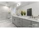 Bright bathroom featuring dual vanity sinks, a large mirror, and a glass-enclosed shower with white tiling at 2226 Revolution Park Dr, Charlotte, NC 28208