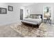 Modern bedroom with neutral decor, large windows, a sitting area, and a patterned area rug at 2226 Revolution Park Dr, Charlotte, NC 28208