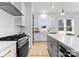 Modern kitchen featuring an island with bar seating, stainless steel appliances, and white subway tile backsplash at 2226 Revolution Park Dr, Charlotte, NC 28208