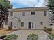 Two-story house exterior with light beige siding, a patio, and landscaping at 2507 Oakdale Creek Ln, Charlotte, NC 28216