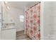 Modern bathroom features double vanity, shower with curtain, and laminate flooring at 310 Black Rock School Rd, Cherryville, NC 28021