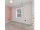 Inviting bedroom with a soft pink accent wall, carpet flooring, and a window with natural light at 310 Black Rock School Rd, Cherryville, NC 28021