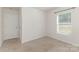 A well lit bedroom with neutral carpet, a window and a closet at 310 Black Rock School Rd, Cherryville, NC 28021