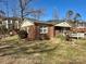 A cozy one-story brick house showcasing mature landscaping and a partially-covered front porch, creating curb appeal at 3520 Carlyle Dr, Charlotte, NC 28208