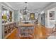 Dining area with hardwood floors leading into an open kitchen with white cabinetry at 390 N Oakwood Dr, Statesville, NC 28677