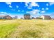 Expansive grassy backyard surrounded by houses and trees under a cloudy blue sky at 425 Webb Rd, Shelby, NC 28152