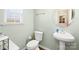 Neutral half bathroom featuring a modern toilet, vanity with a sink, and a window for natural light at 425 Webb Rd, Shelby, NC 28152