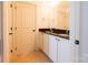 Double vanity bathroom with black countertops and white cabinets with tile floor at 712 Kenway Loop, Mooresville, NC 28117