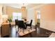 Cozy dining room with hardwood flooring, elegant light fixture, and traditional style with wainscoting at 712 Kenway Loop, Mooresville, NC 28117