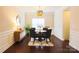 Cozy dining room with hardwood flooring, elegant light fixture, and traditional style with wainscoting at 712 Kenway Loop, Mooresville, NC 28117