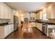 Well-lit kitchen featuring stainless steel appliances, white cabinetry, and a view to an adjacent dining area at 712 Kenway Loop, Mooresville, NC 28117