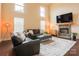 Cozy living room features a stone fireplace, large windows and comfortable seating at 712 Kenway Loop, Mooresville, NC 28117