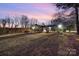 Lush backyard with a view of the home's screened-in porch and surrounding trees at 78 Scalybark Trl, Concord, NC 28027