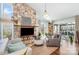 Sunlit living room with a stone fireplace, hardwood floors, and access to a screened porch at 78 Scalybark Trl, Concord, NC 28027