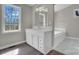 Bathroom with white vanity, large mirror, and soaking tub at 7921 Fairmont Dr, Waxhaw, NC 28173