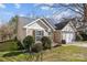 Attractive single-story home with neutral siding, dark shutters, manicured landscaping, and a two car garage at 8218 Deodora Cedar Ln, Charlotte, NC 28215