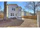 Backyard view of a two-story home with a fenced-in yard and mature trees at 1211 Pinecrest Ave, Charlotte, NC 28205