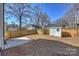 Backyard view of privacy fence and storage shed with small concrete patio at 1211 Pinecrest Ave, Charlotte, NC 28205