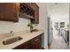 Bar area with dark wood cabinets, a wine rack, a sink, and granite countertops at 1211 Pinecrest Ave, Charlotte, NC 28205
