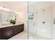 Elegant bathroom showcasing a double vanity, a large mirror, and a glass-enclosed shower with tiled walls at 1211 Pinecrest Ave, Charlotte, NC 28205
