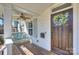 Inviting front porch with a cozy swing, ceiling fan, and charming wreath on the front door at 1211 Pinecrest Ave, Charlotte, NC 28205