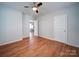 A bright bedroom with hardwood floors, ceiling fan, two windows, and a hallway view at 1213 Cloninger Ave, Gastonia, NC 28052