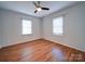 A bright bedroom with two windows, blinds, hardwood floors, and a ceiling fan for comfortable living at 1213 Cloninger Ave, Gastonia, NC 28052