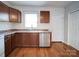 A well-lit kitchen with wood-look flooring, brown cabinets, a stainless steel dishwasher, and a stainless steel sink at 1213 Cloninger Ave, Gastonia, NC 28052