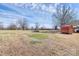Expansive backyard showcasing the main house, shed, mature trees, and blue sky at 1354 Mirror Lake Rd, Lincolnton, NC 28092