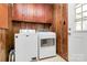 Practical laundry area featuring side-by-side washer and dryer and overhead storage at 1354 Mirror Lake Rd, Lincolnton, NC 28092