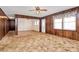 Comfortable living room with wood paneling, ceiling fan, and open access to other rooms at 1354 Mirror Lake Rd, Lincolnton, NC 28092
