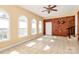 Bright living room with three large windows, ceiling fan, and unique brick accent wall at 1354 Mirror Lake Rd, Lincolnton, NC 28092