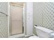 Shower area with glass doors, patterned wallpaper and white tile at 1354 Mirror Lake Rd, Lincolnton, NC 28092