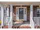 Charming brick home entrance featuring a white-trimmed door, classic columns, and decorative outdoor lighting at 144 Cameron Dr, Salisbury, NC 28147
