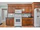 Well-lit kitchen with dark wood cabinets, white appliances, black countertops and hardwood flooring at 144 Cameron Dr, Salisbury, NC 28147