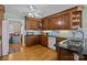 Classic kitchen featuring dark wood cabinetry, black countertops, stainless steel sink, and hardwood flooring at 144 Cameron Dr, Salisbury, NC 28147