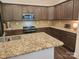 Kitchen with dark wood cabinets, granite countertops, stainless steel appliances and island at 184 Flat Rock Dr, Denver, NC 28037