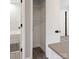 Hallway view featuring a storage closet, bathroom, and modern gray laminate flooring at 2000 Patio Ct # 101, Charlotte, NC 28205